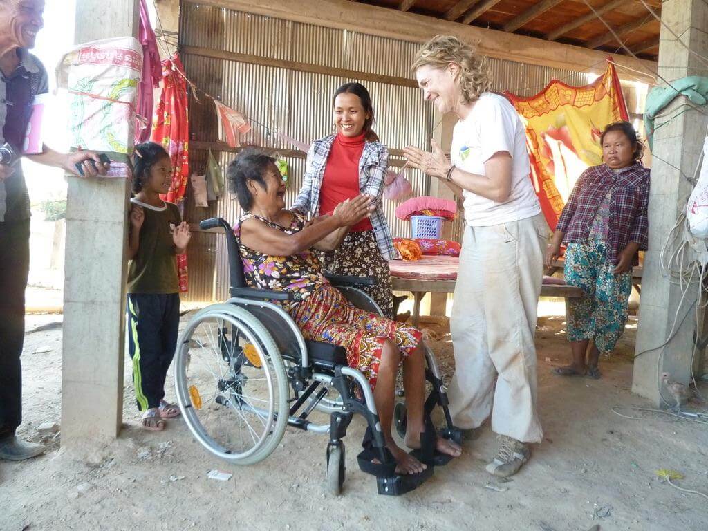 Kambodschanische Frau im Rollstuhl lacht Doerte an.