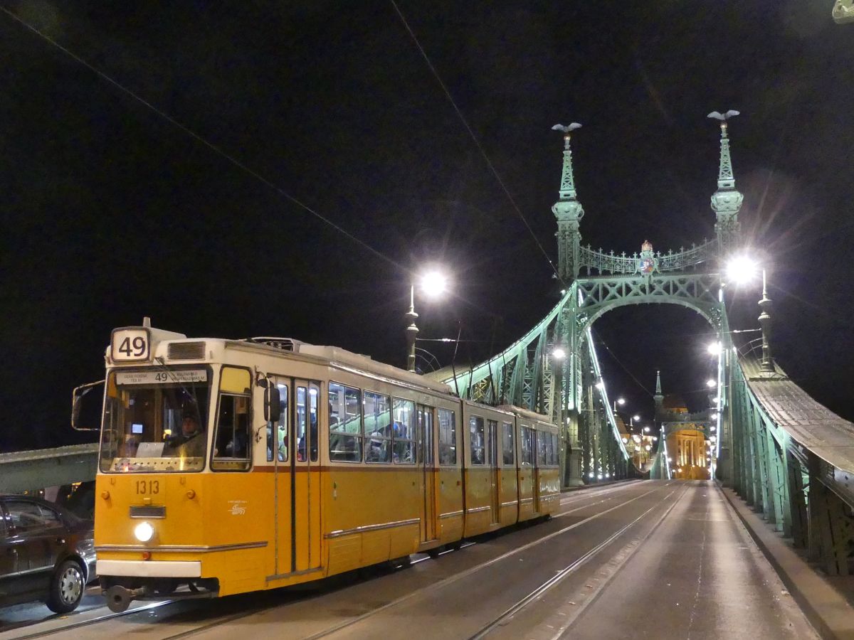 Gelbe Straßenbahn bei Nacht.