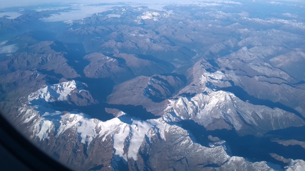 Luftaufnahme von schneebedeckten Gipfeln der Alpen.