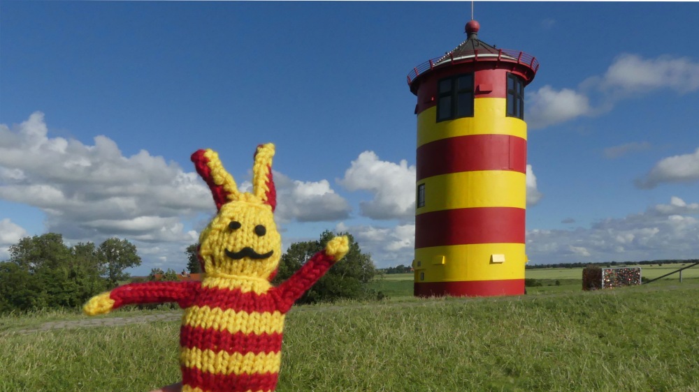 Rot-gelber Reise-Ringel neben rot-gelbem Leuchtturm.