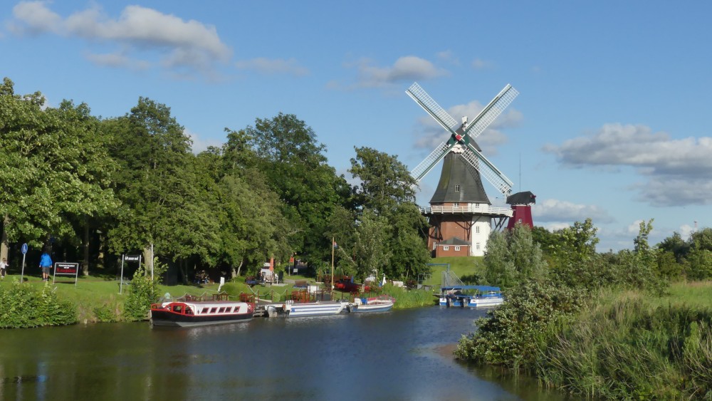 Wasserkanal mit zwei Windmühlen am Rand.