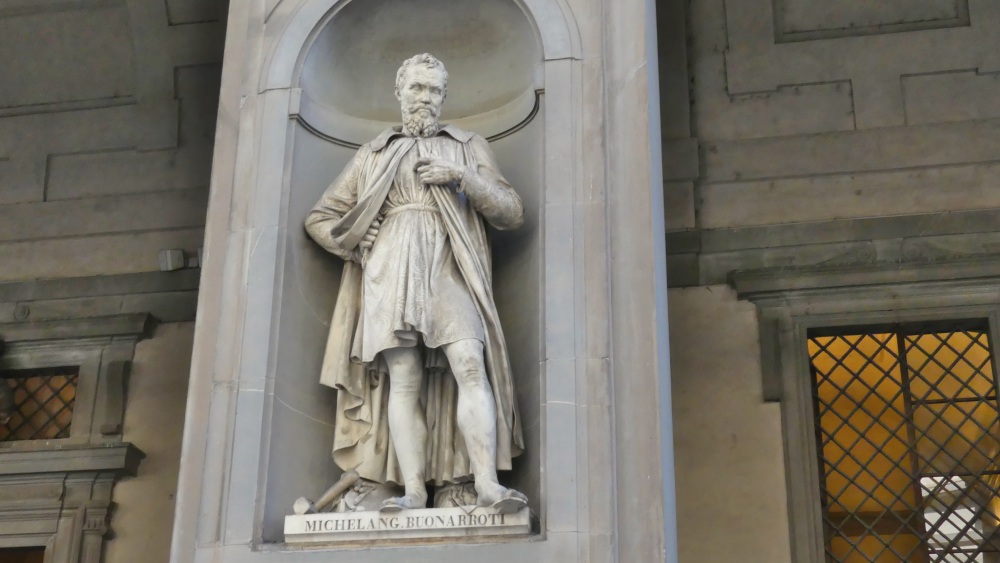 Statue des Michelangelo in einer Mauernische vor den Uffizien.