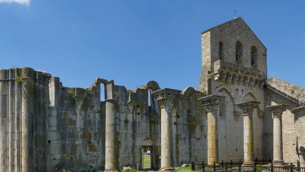 Ruine einer großen Kirche mit Außenmauer und Säulen.