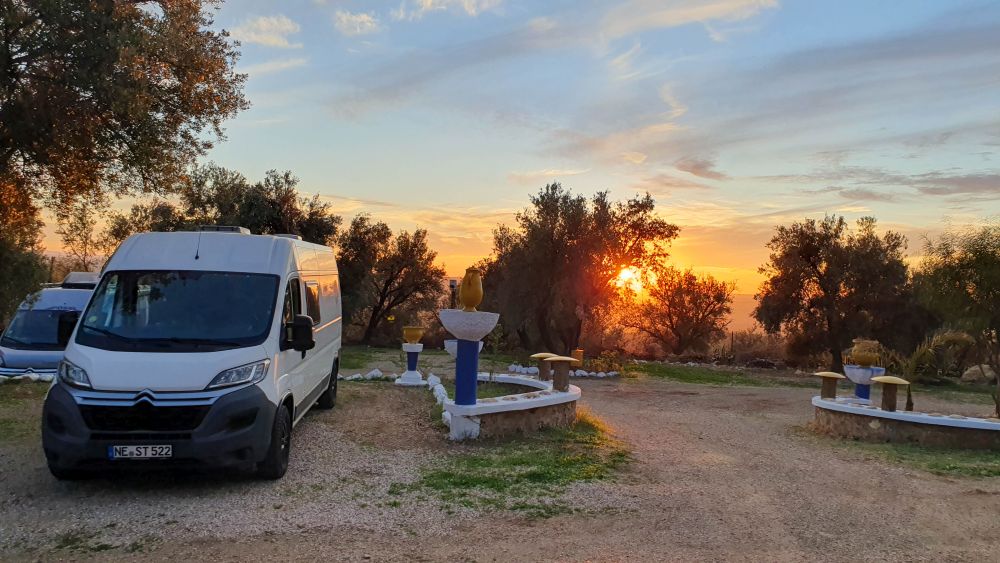 Wohnmobil auf Campingplatz vor Sonnenuntergang.