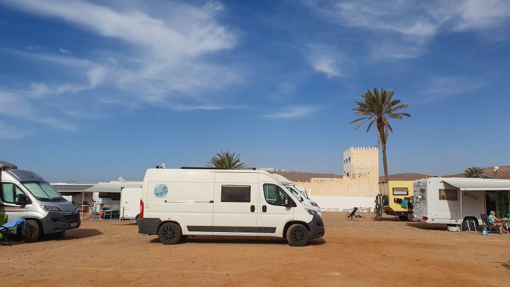 Viele Wohnmobile stehen eng auf einem Campingplatz in Marokko.