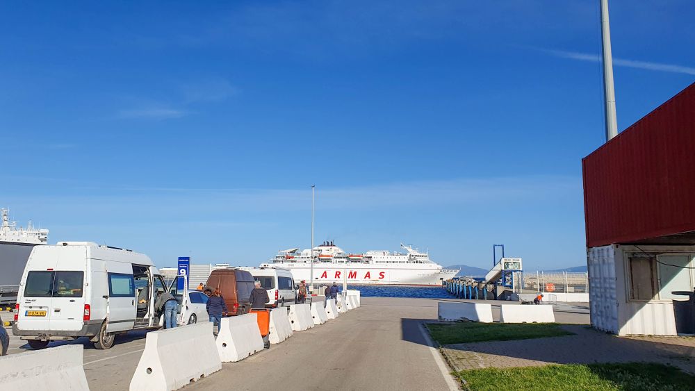 Autos und Wohnmobile warten am Fährhafen auf die Fähre.