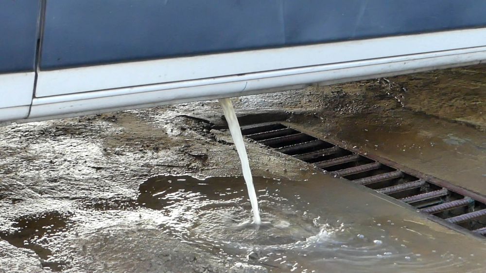 Grauwasser fließt aus dem Bodenablass des Wohnmobils in ein Ablaufgitter.