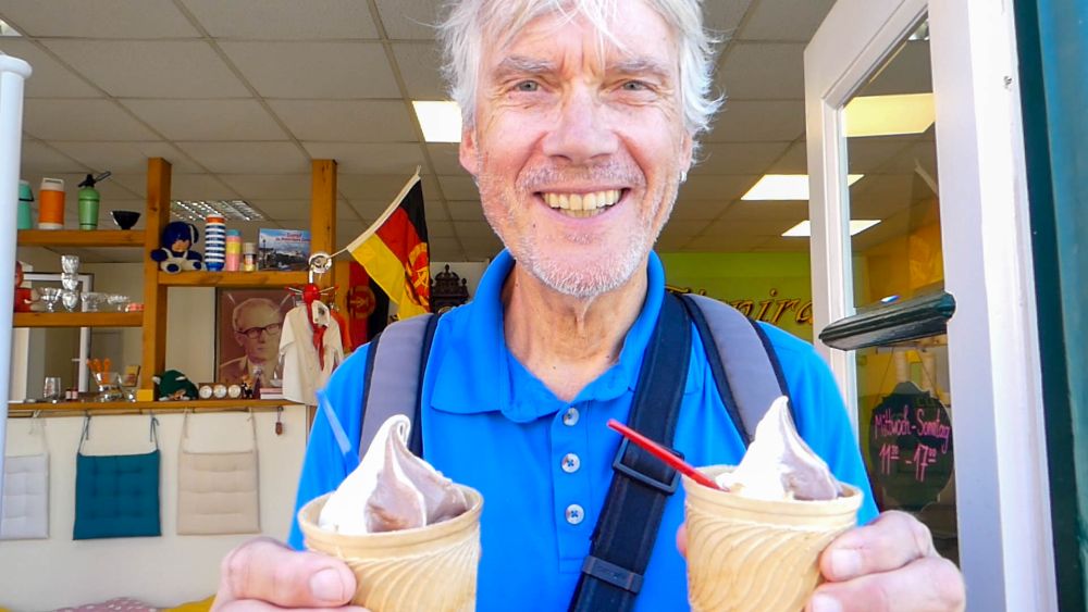 Marcus hält strahlend zwei Eisbecher mit Softeis in der Hand.