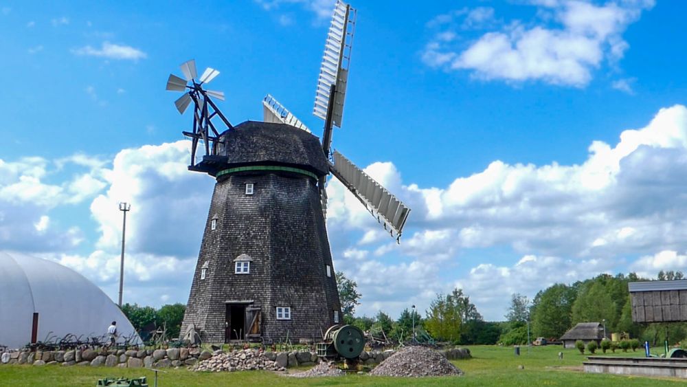 Holländer-Windmühle vor blauem Himmel mit einzelnen Wolken.