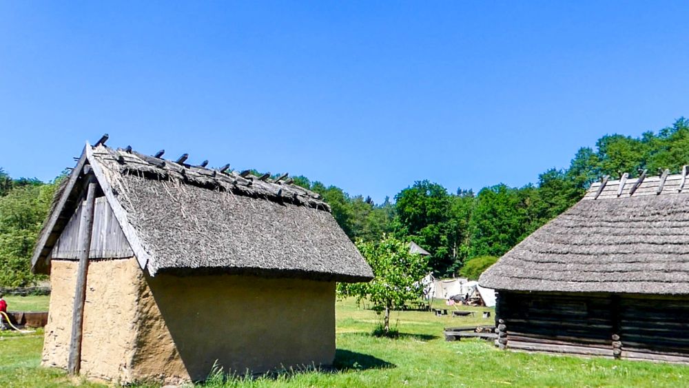 Einfache Hütten mit Lehmwänden und Holzdächern.