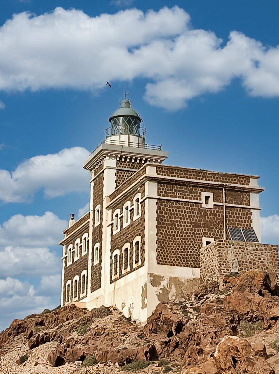 Großes braun-weißes Gebäude, das den Leuchtturm bildet.