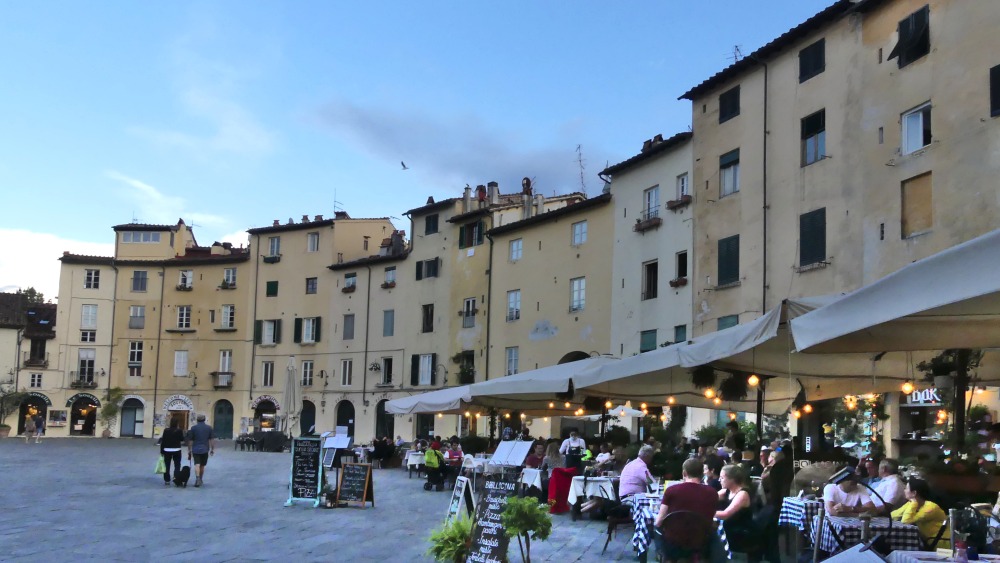 Piazza Anfiteatro mit vielen Restaurant-Tischen.